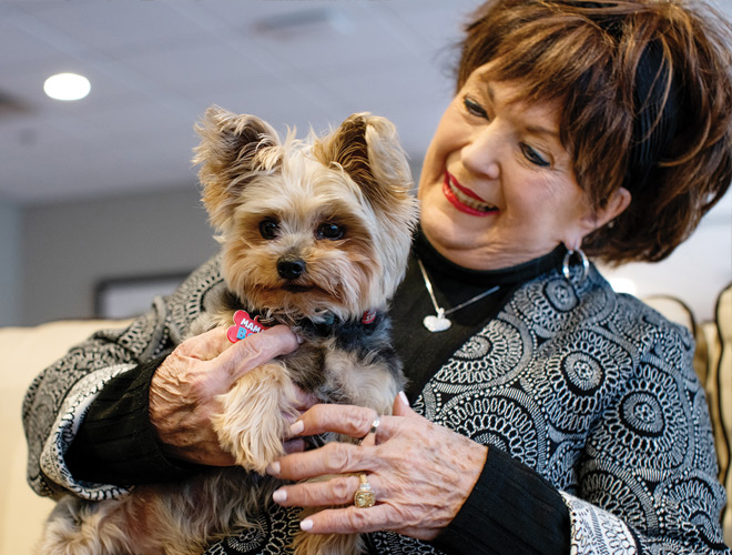 A resident is holding a dog.