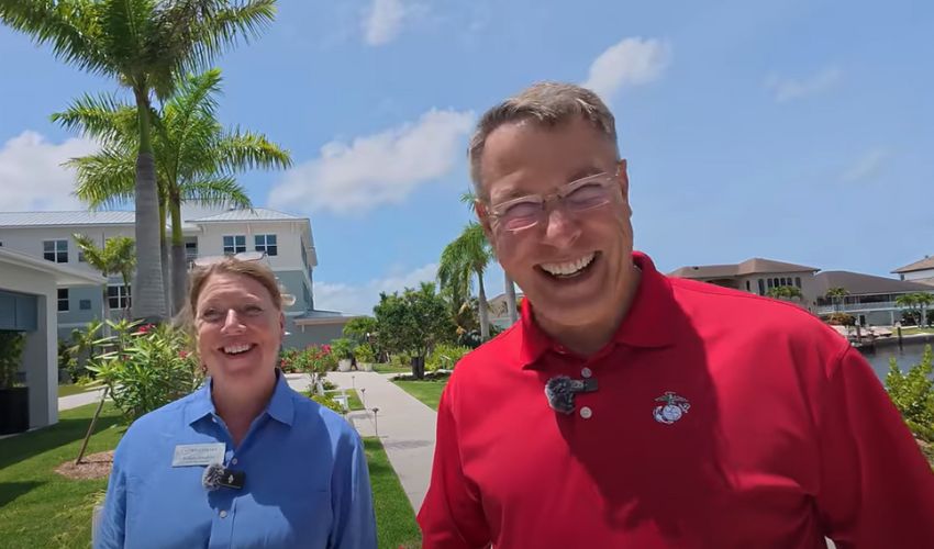 A visitor and an associate are laughing outside.