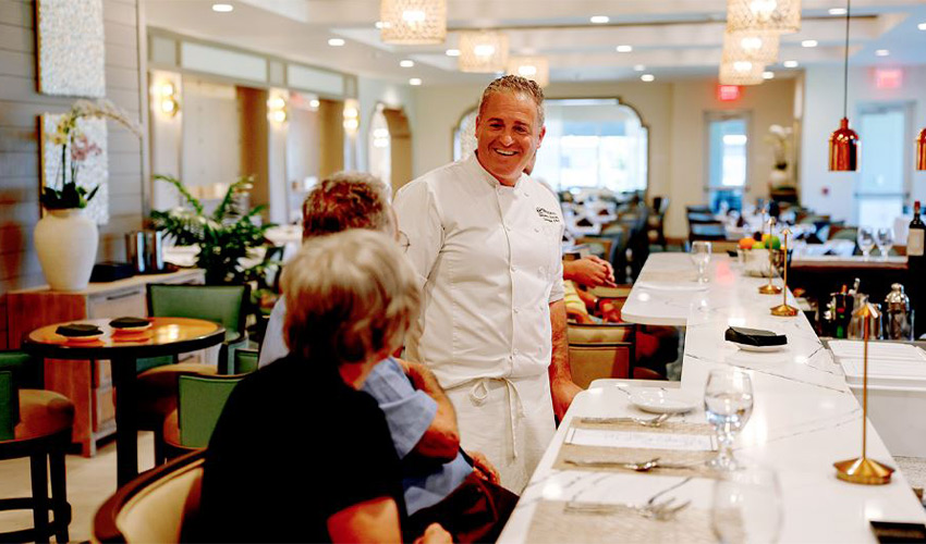 A chef and the residents are at a restaurant in the community.