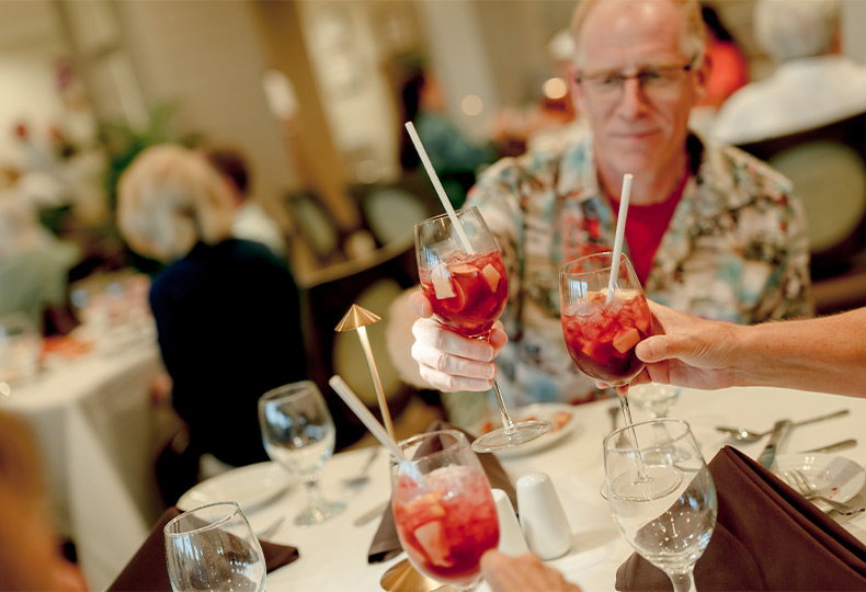 People toasting with fruity drinks.