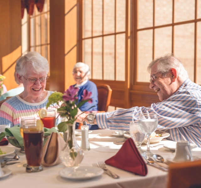 A couple enjoying dinner. One of them is sneaking food off the others plate.