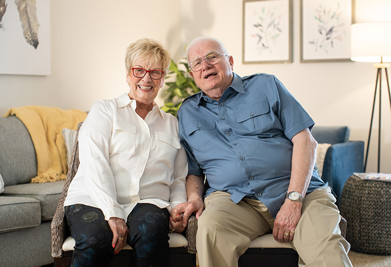 Couple sitting down on chairs.