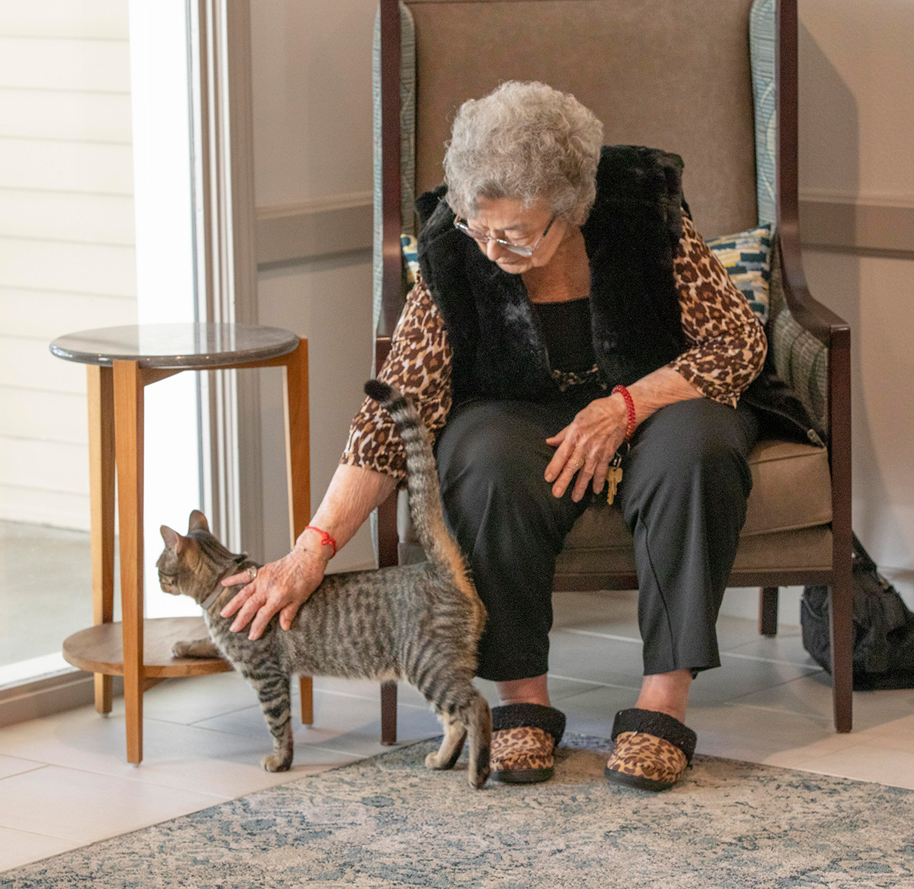 A resident is petting a cat.