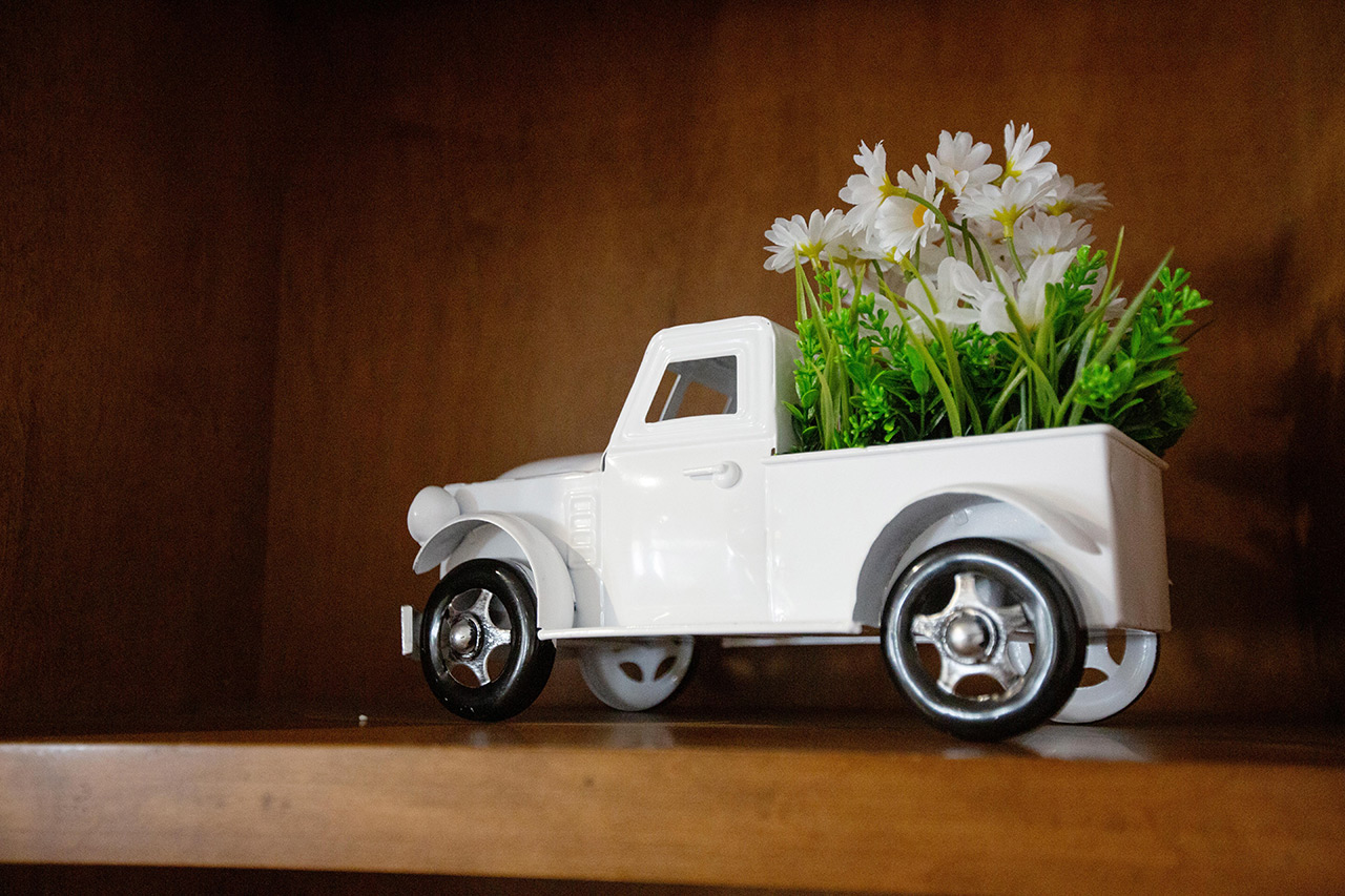 A shelf with a ceramic truck decoration.