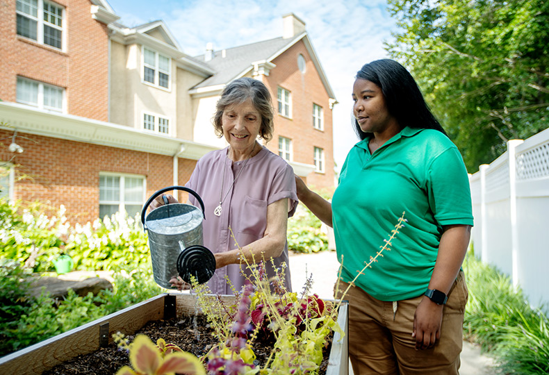 A resident in the garden with a caregiver.