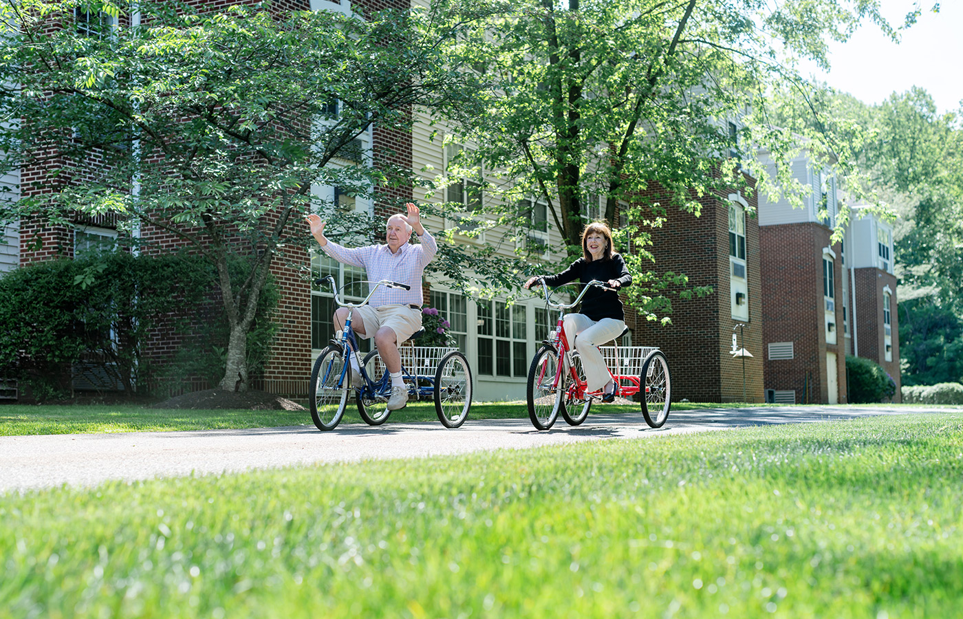 Two people riding bikes outside.