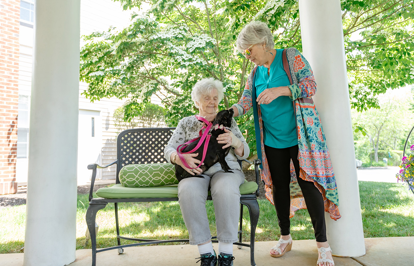 A person with a dog on their lap outside.