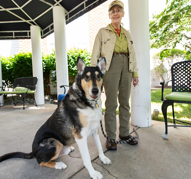 A person standing with their dog outside.