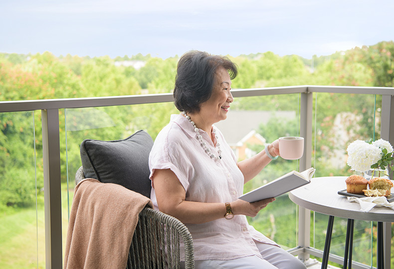 A resident on the balcony having coffee.