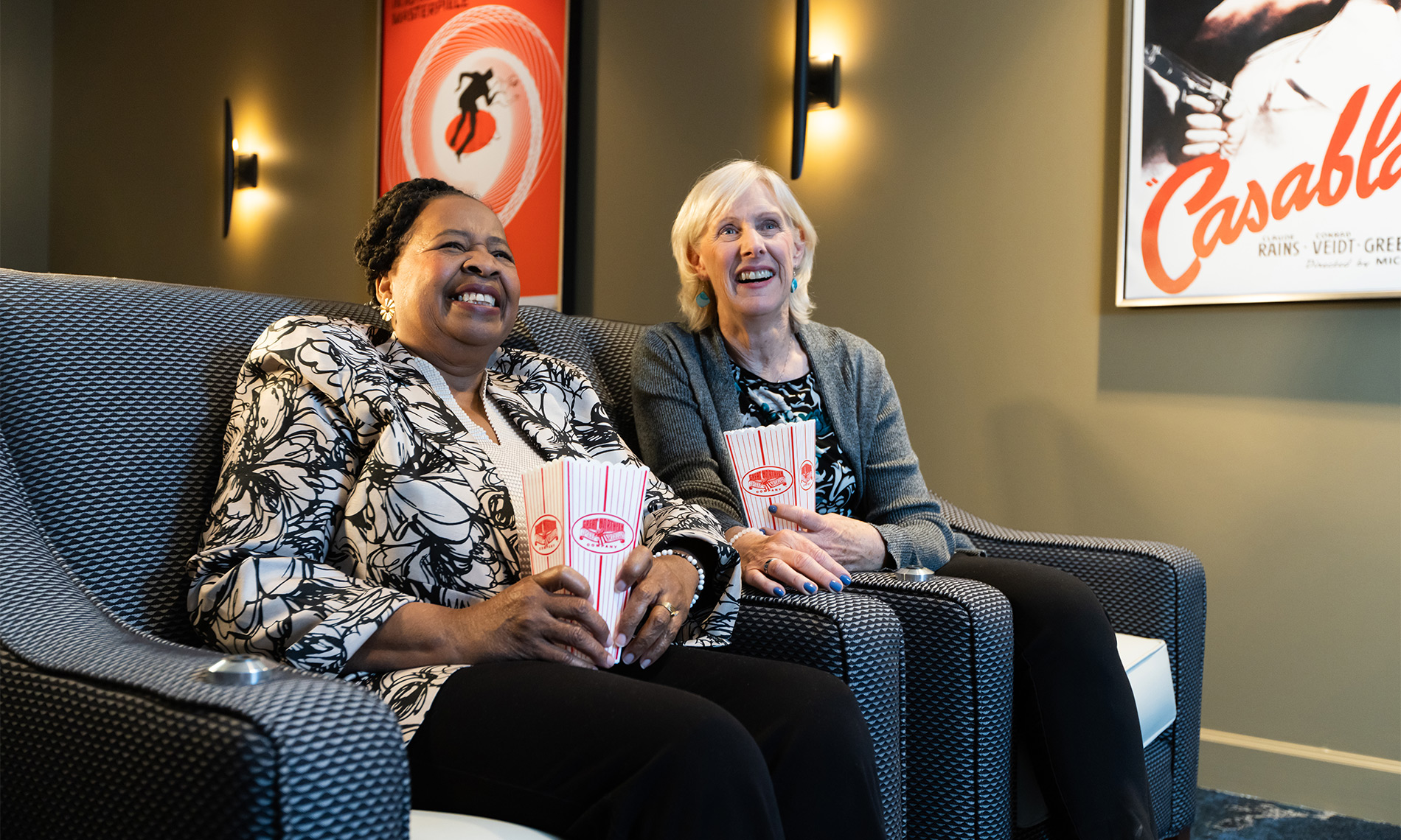 Two people watching a movie with popcorn.