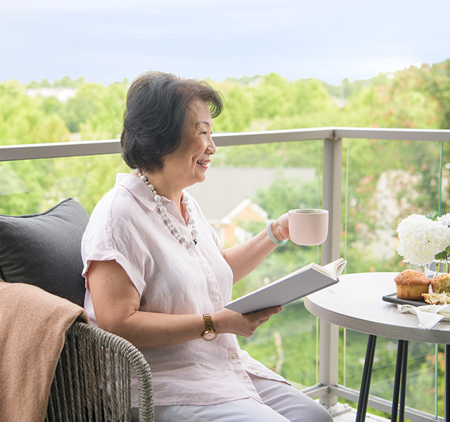 A resident sitting on the balcony having coffee.