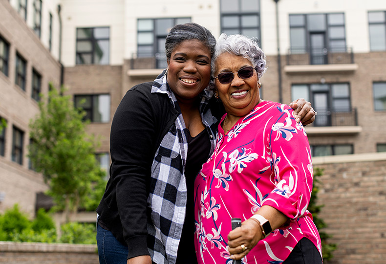 An adult child and resident embracing.