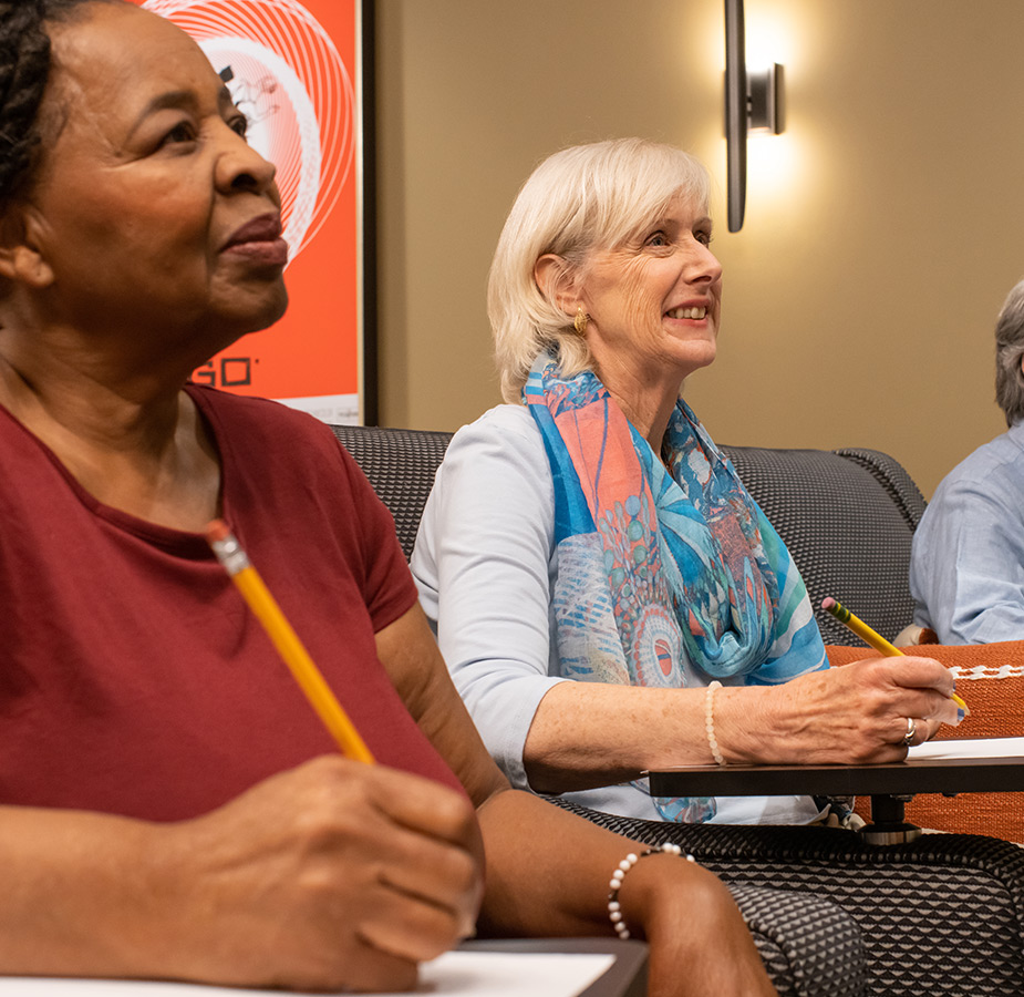 People in a class with pencils and paper.