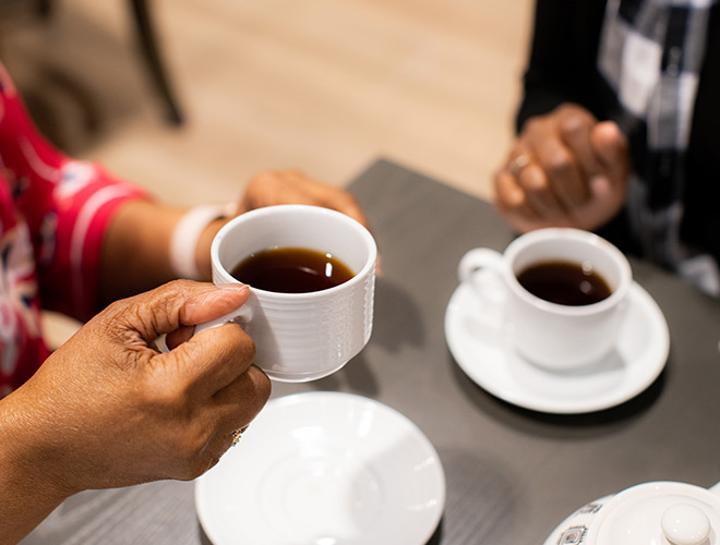 Hands holding cups of coffee.