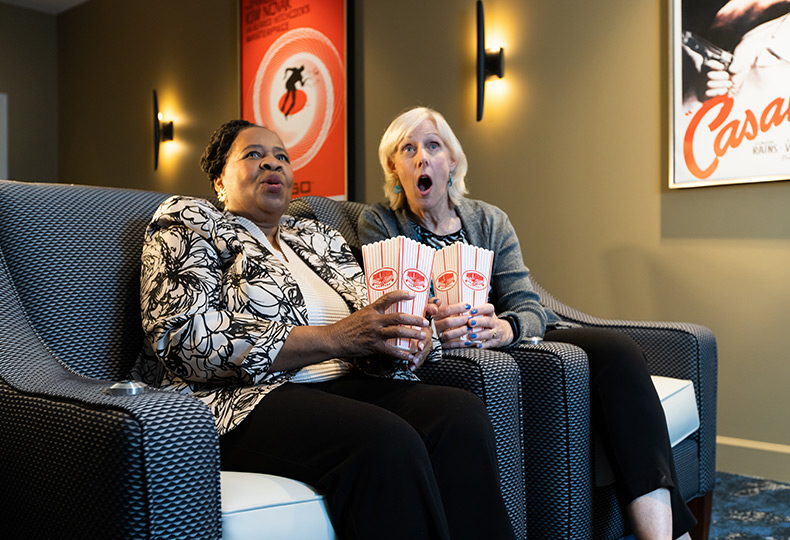 Two people in a theater reacting to a movie.