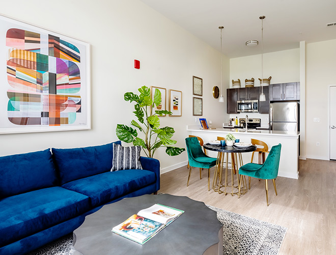 A fully furnished living room looking into the kitchen.