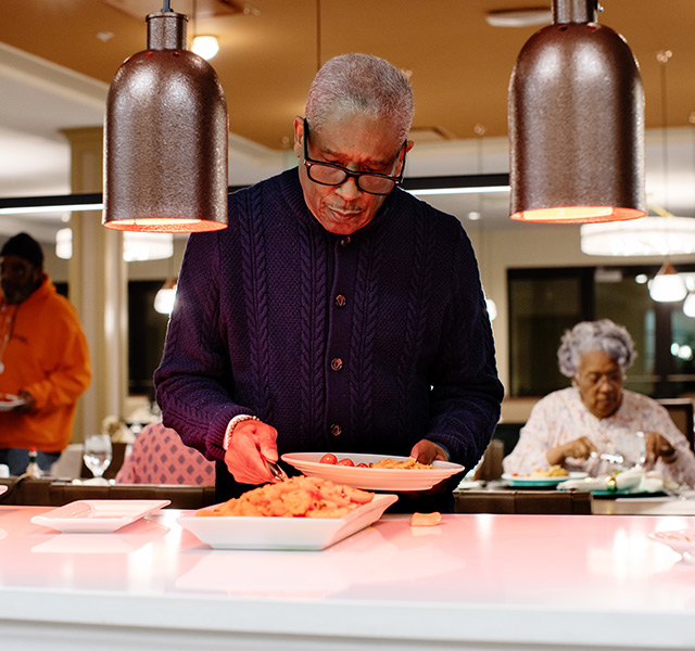 A person getting food from a buffet.