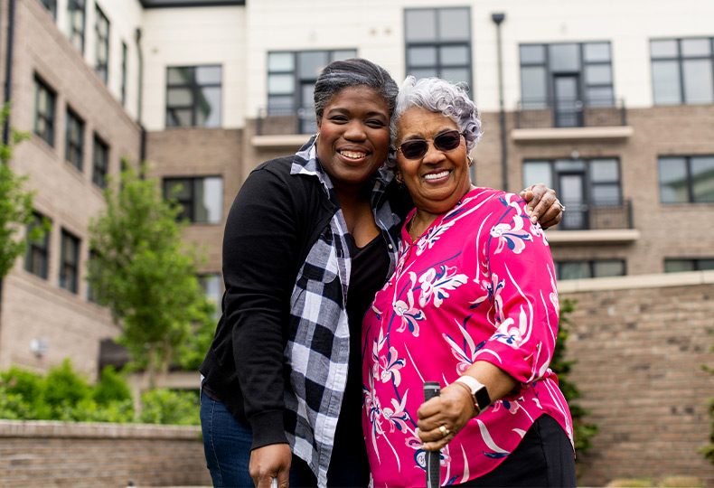 Two people outside smiling.