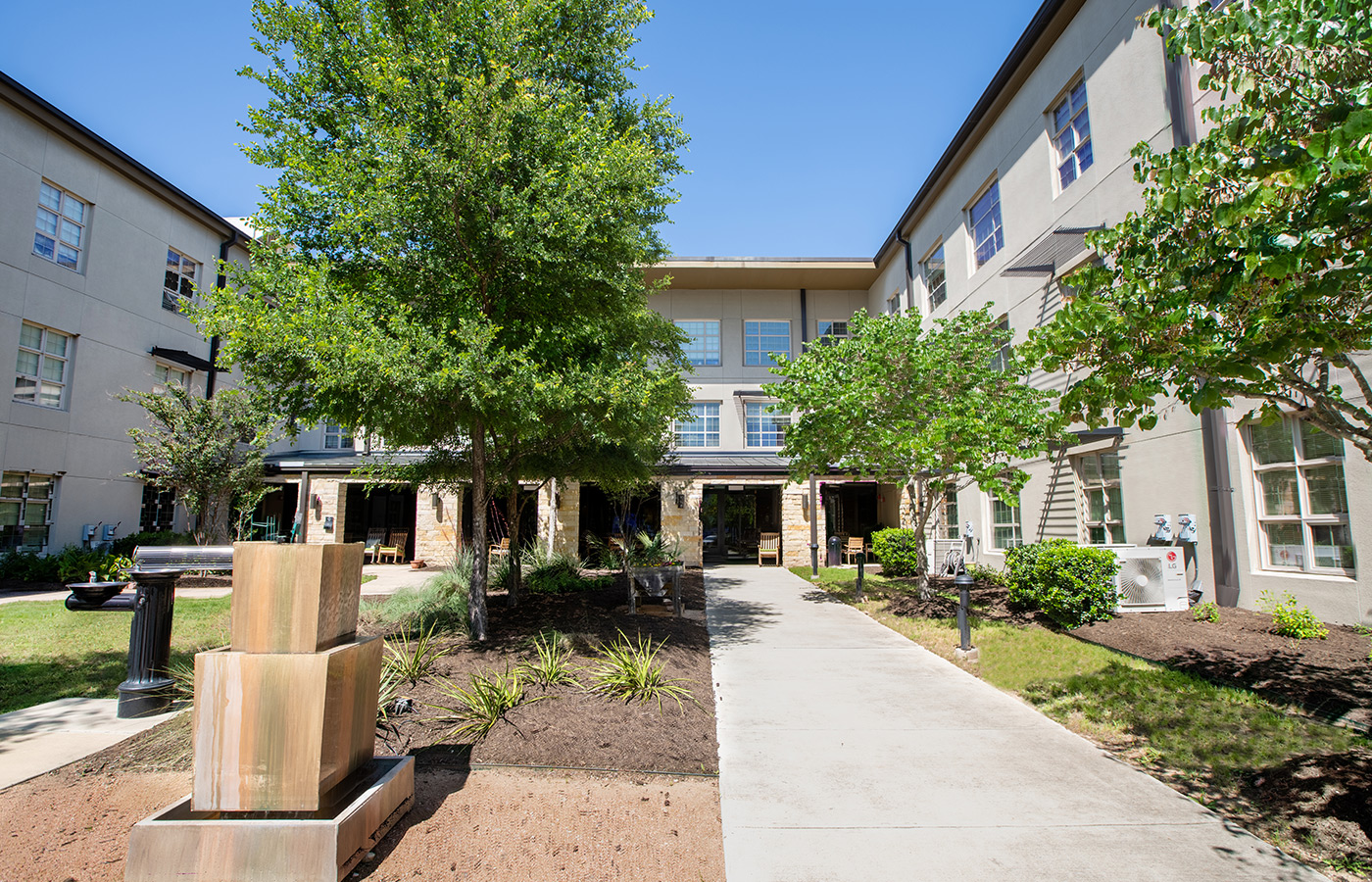 A garden with a fountain and walkway.