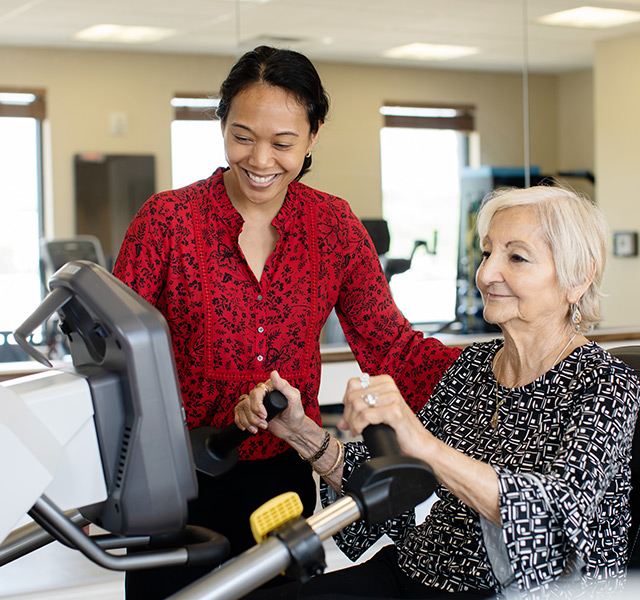 A resident working in the fitness center with a physical therapist.