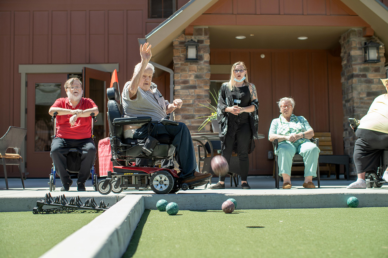 Residents are outside playing bocce ball.