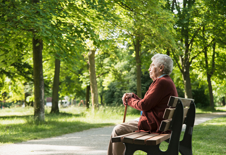 A person sitting on a bench in the park.