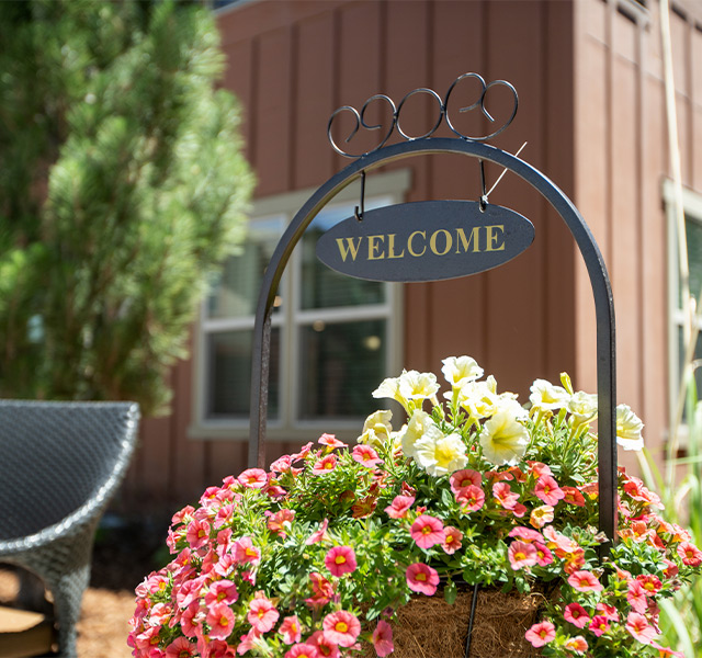 A welcome sign in a bed of flowers.