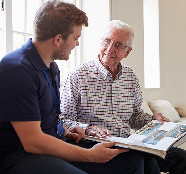 A resident is reading a book with another person.