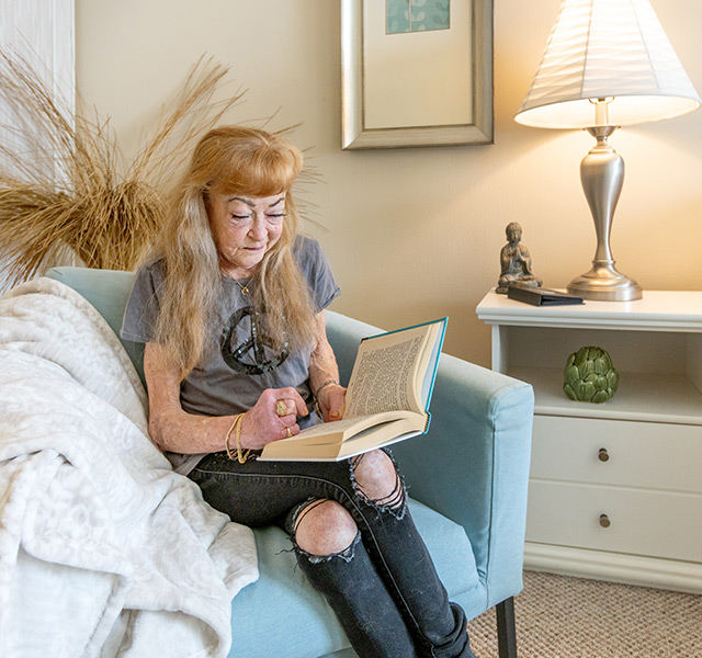 A resident is sitting down reading a book.