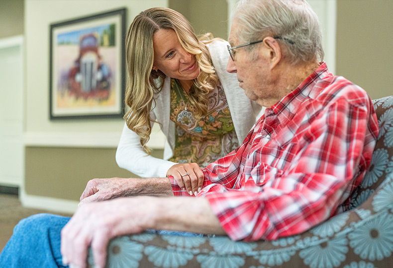 A caregiver is talking to a resident.