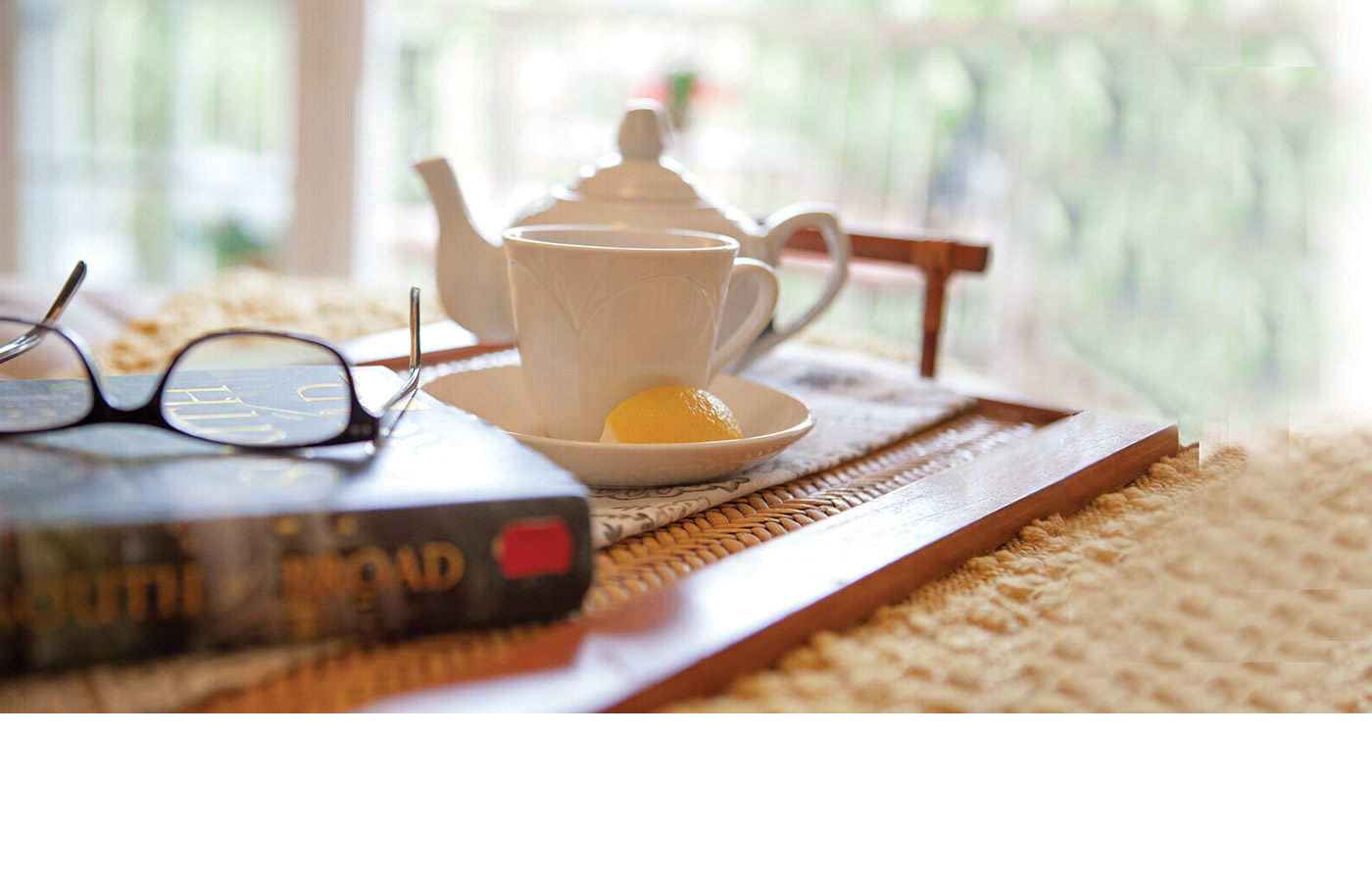 A welcoming tea pot with a book beside it 