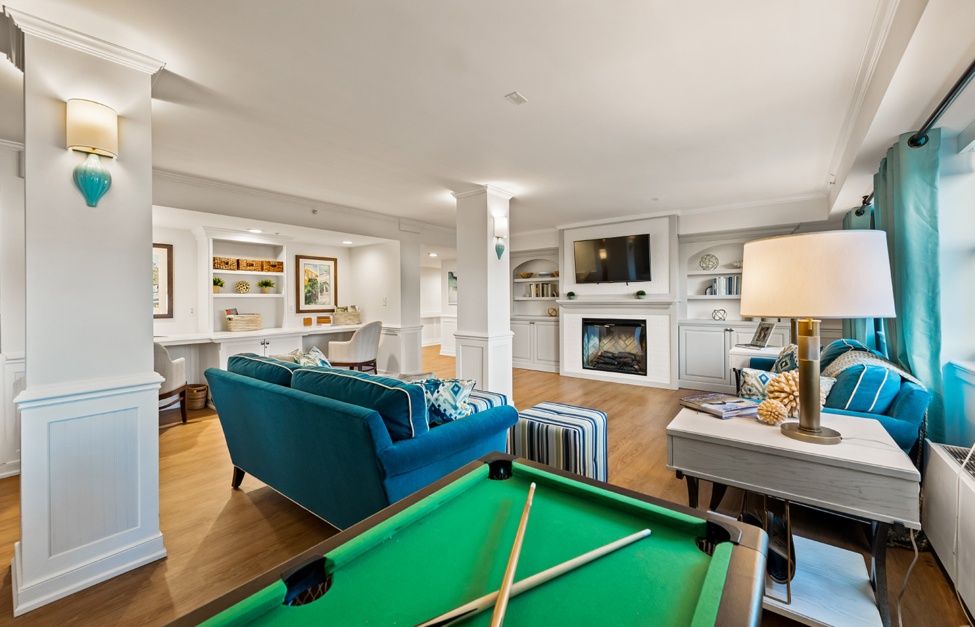 Activity room with a pool table, couch, and fireplace.