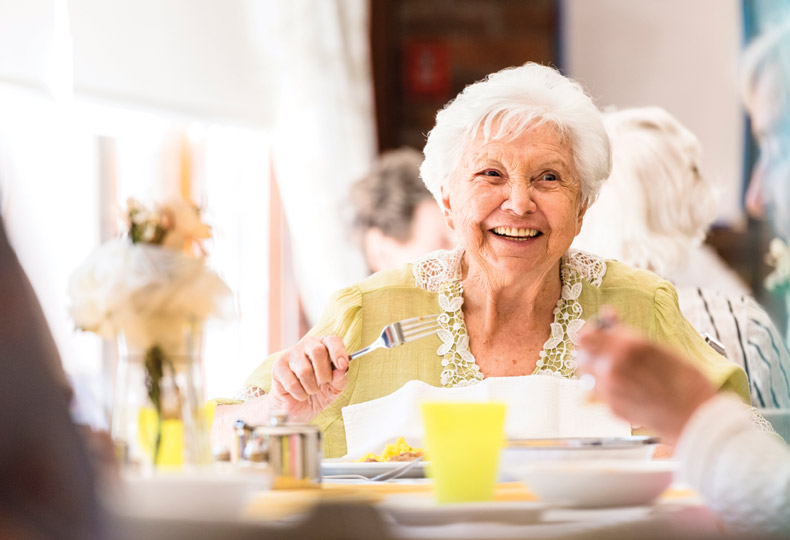 A resident having dinner and laughing.