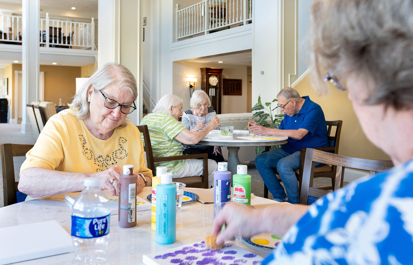 Two residents are painting in an art class.