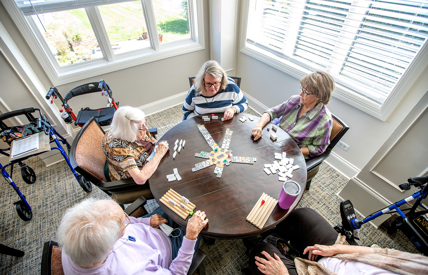 A group of residents are sitting around a table playing a game together.