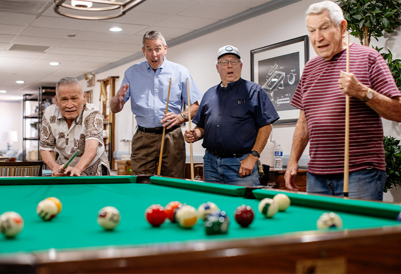 A group of people playing pool.