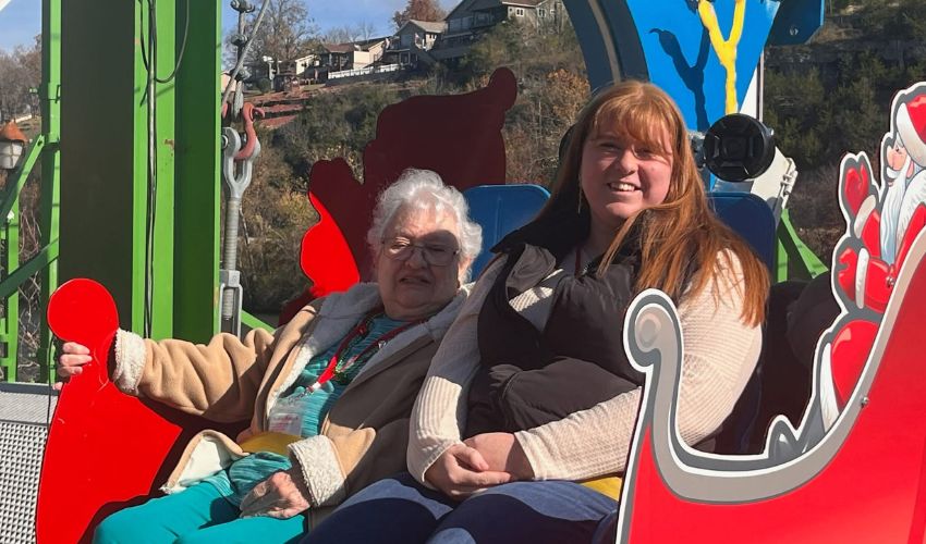 An associate is sitting in a sleigh with a resident.