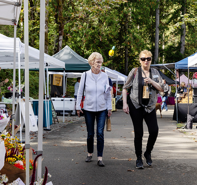 People walking through a farmers market.