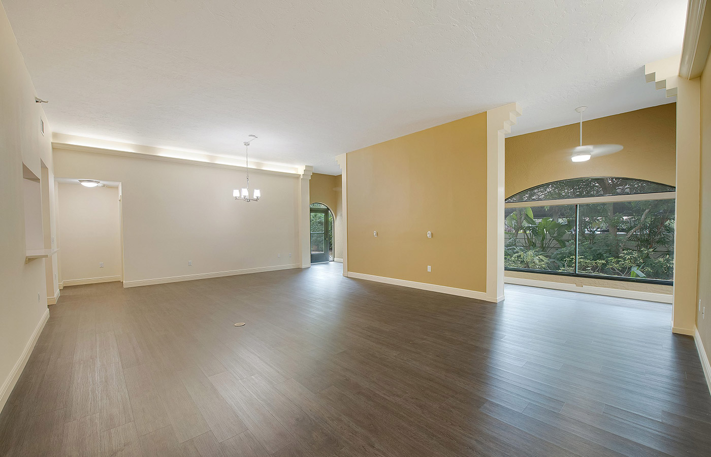 large spacious living room area with hardwood floors and large windows