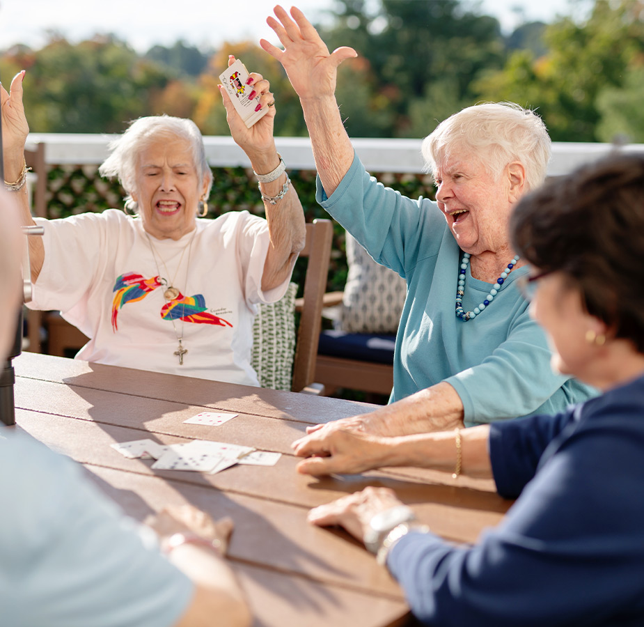 A group of people playing cards outside.