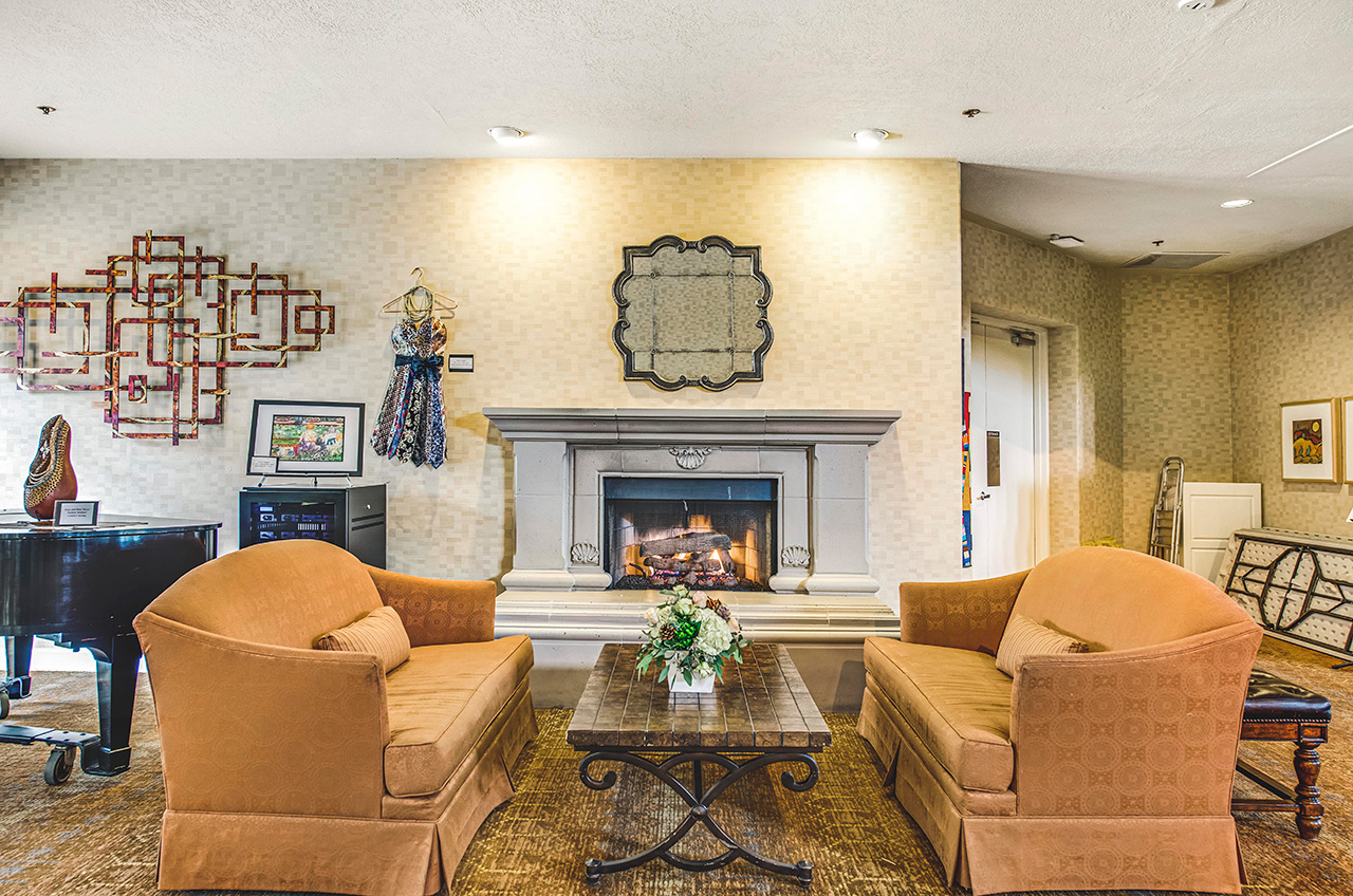 A seating area in front of a fireplace at The Fountains at La Cholla.