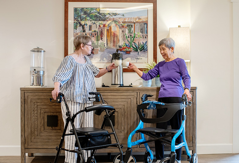 Two people with walkers getting coffee.