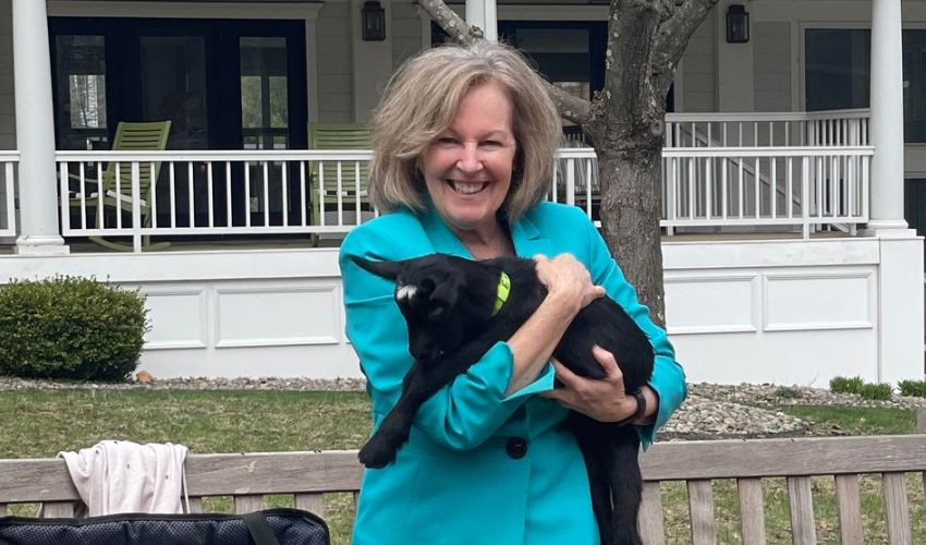 A resident is holding a goat.