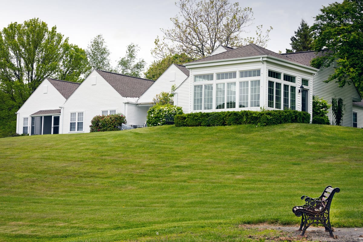 The Fountains at Millbrook white cottage on top of a green hillside.