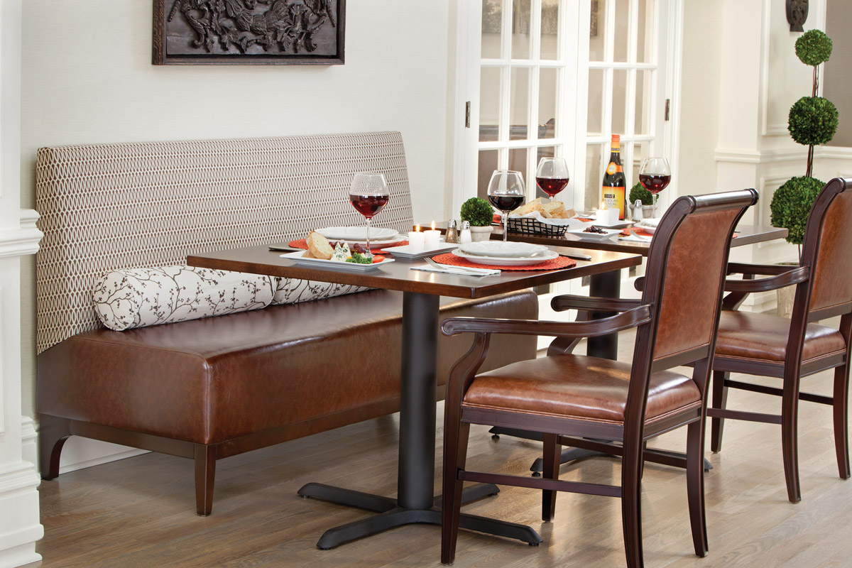 Dining room with seating area and set plates.