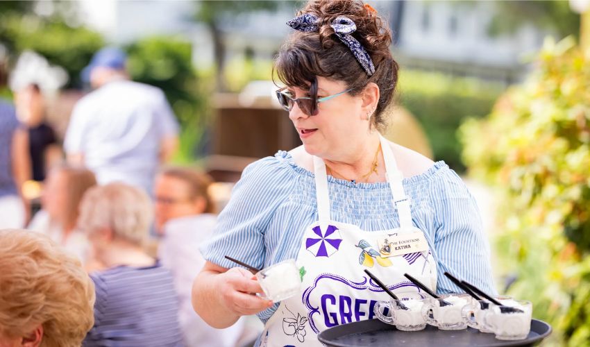 A person serving cups of ice cream.