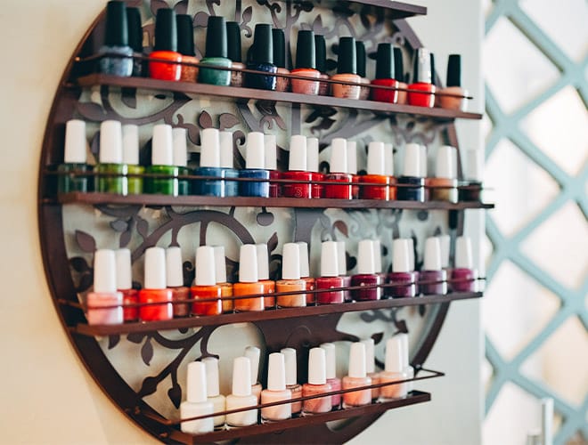 A shelf lined with nail polish in a variety of vibrant colors.