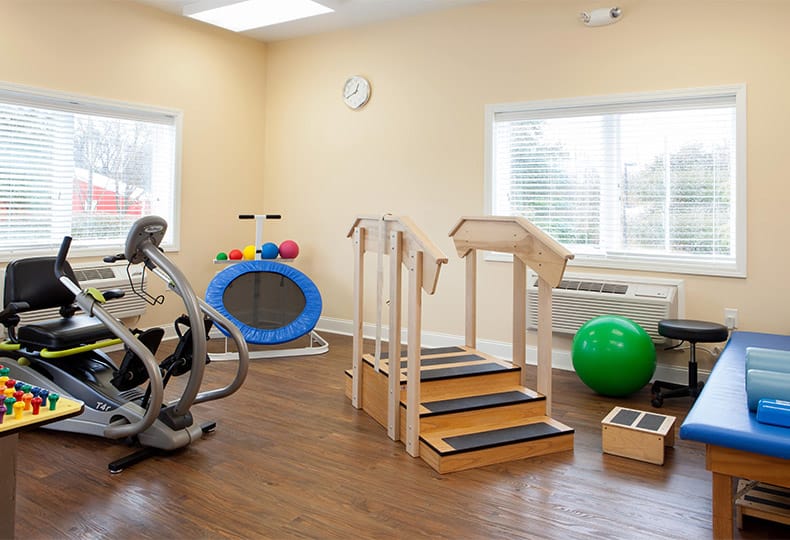 An assortment of fitness equipment including a bike, trampoline and stairs with railing found on-site at The Fountains at The Albemarle.