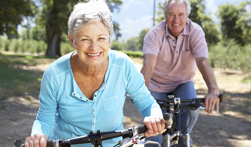 A senior man and woman riding bikes.