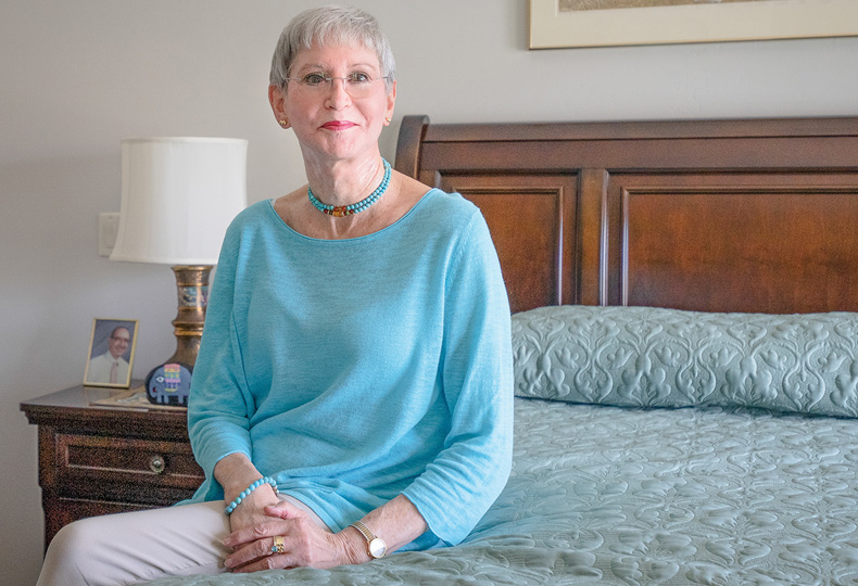A resident is sitting on a bed.